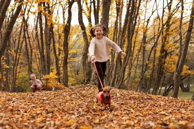 Full shot girls with dog in nature