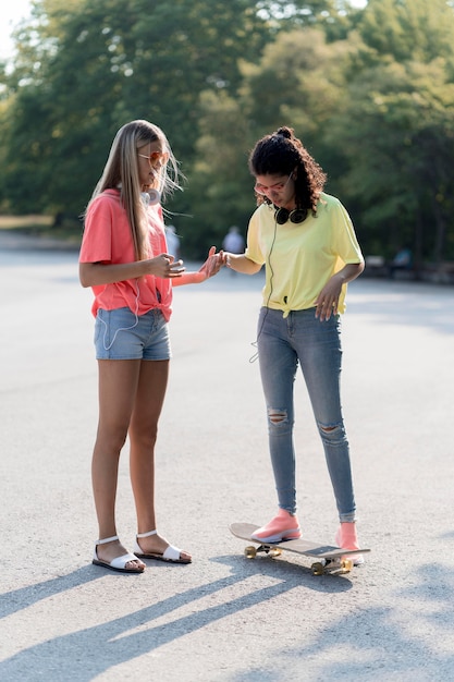 Ragazze del colpo pieno con lo skateboard