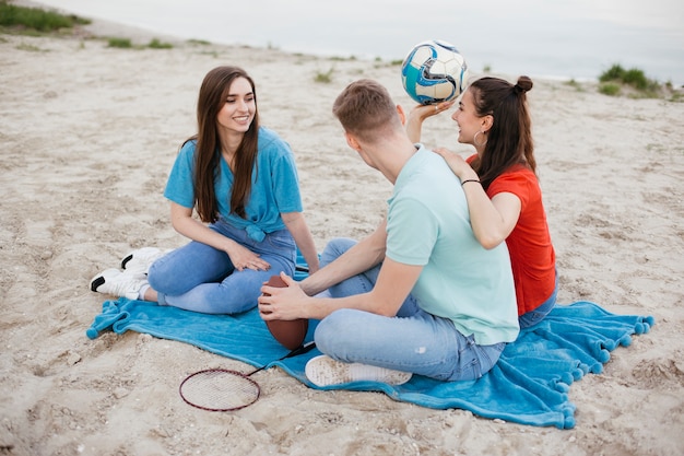 Full shot group of friends on the beach