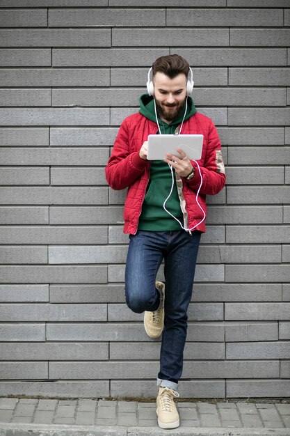 Full shot guy with headphones and tablet