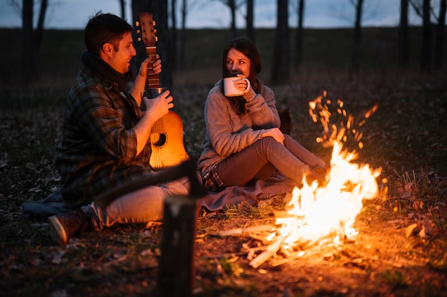 Free photo full shot happy couple holding guitar