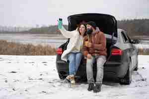 Free photo full shot happy couple with car