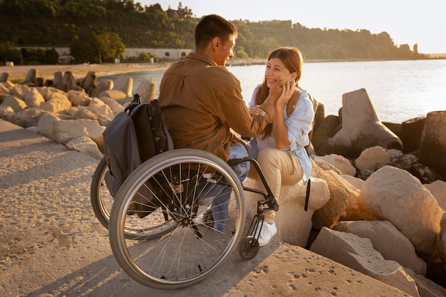 Free photo full shot happy couple with wheelchair