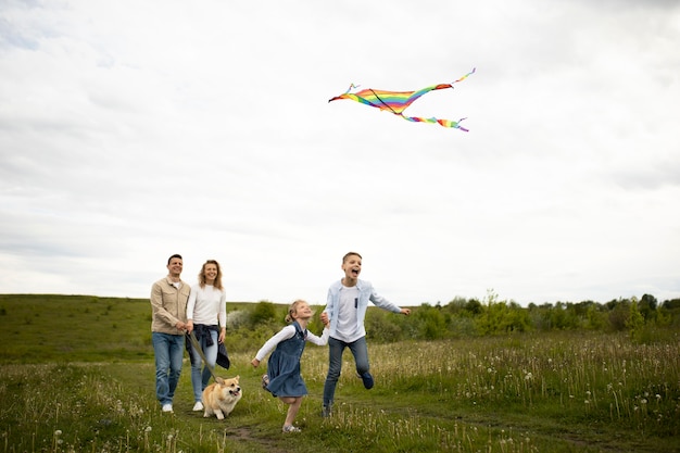 Full shot happy family flying kite