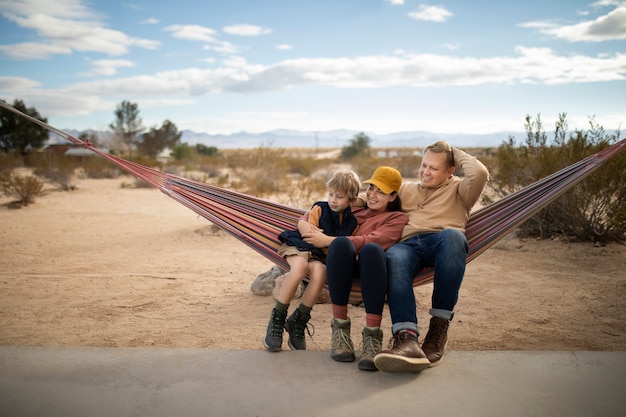 Full shot happy family on hammock