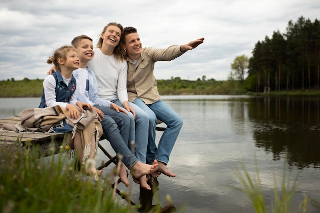 Free photo full shot happy family outdoors