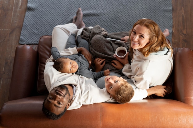 Full shot happy family sitting on couch