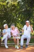 Free photo full shot happy friends sitting on bench