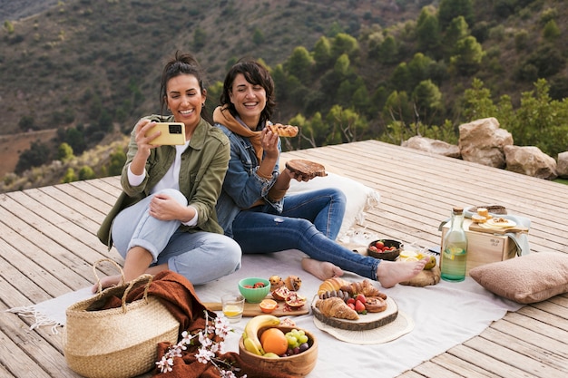 Full shot happy friends with delicious food