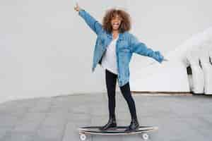 Free photo full shot happy girl on skateboard