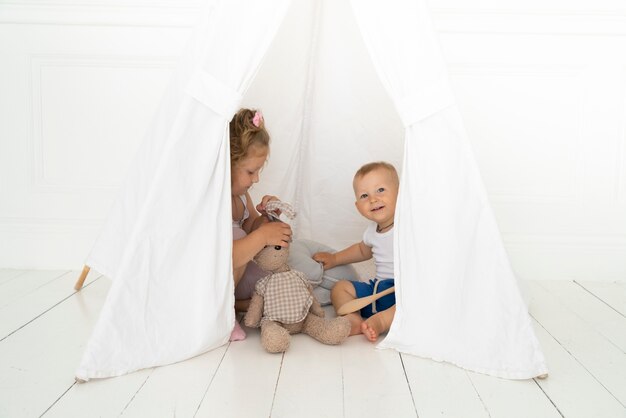 Full shot happy kids under tent