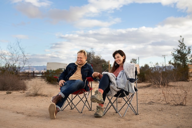 Free photo full shot happy partners sitting on chairs