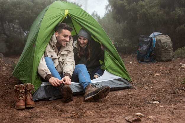 Full shot happy people in green tent