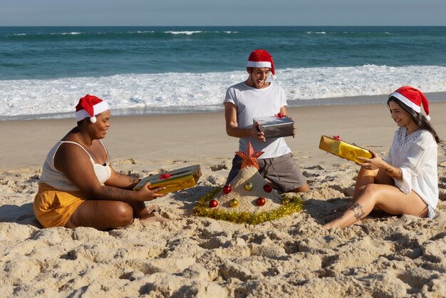 해변에서 선물을 들고 있는 전체 샷 행복한 사람들