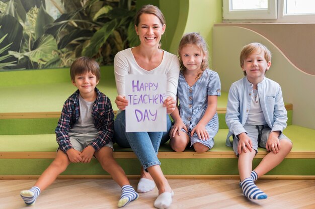 Full shot happy teacher posing with kids