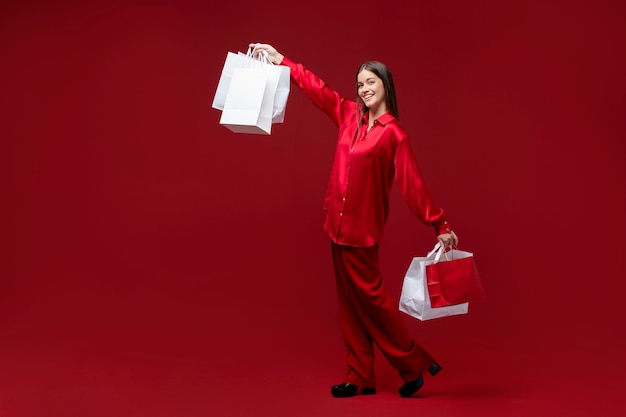 Full shot happy woman holding shopping bags