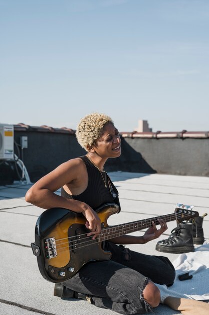 Full shot happy woman playing guitar