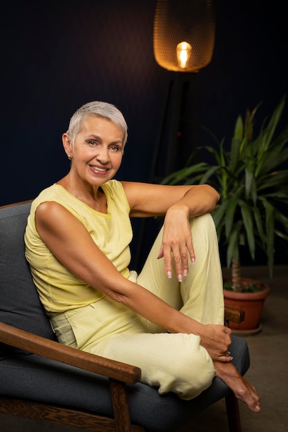 Full shot happy woman sitting on chair