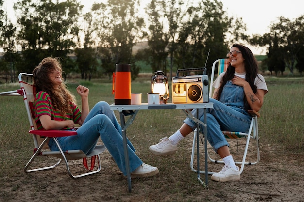 Free photo full shot happy women sitting on chairs