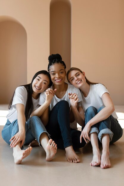 Full shot happy women sitting on floor