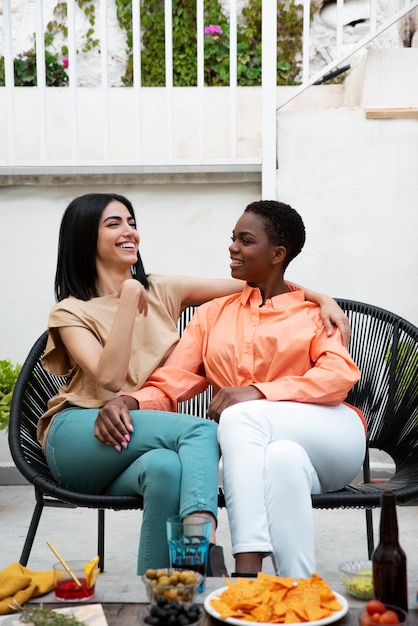 Free photo full shot happy women sitting together