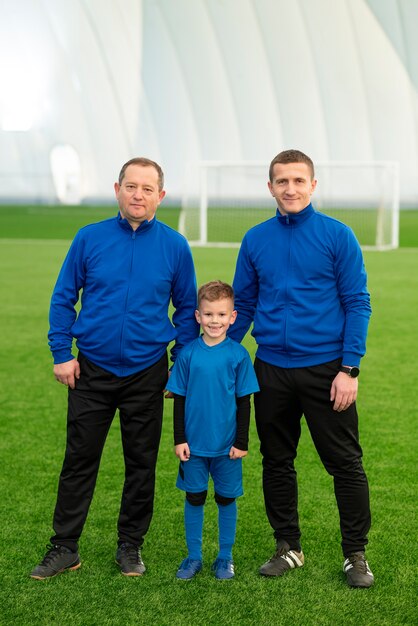 Full shot kid and adults on field