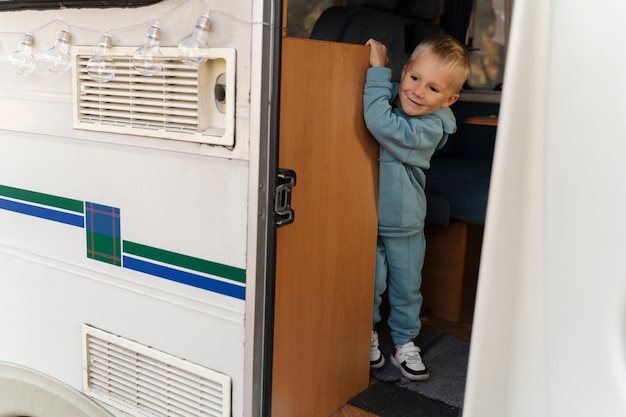 Free photo full shot kid in campervan