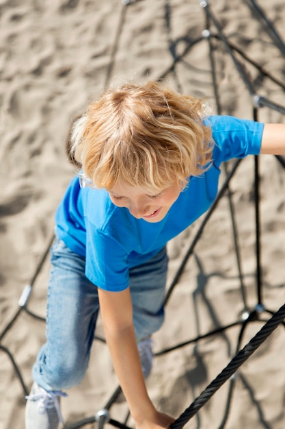 Free photo full shot kid climbing rope