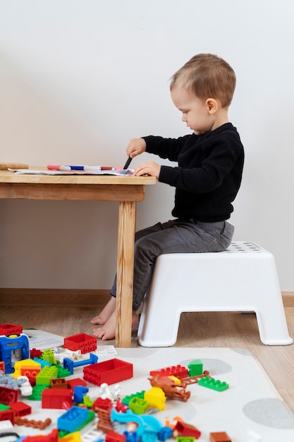 Full shot kid drawing at table