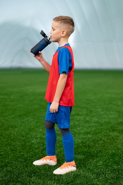 Full shot kid drinking water