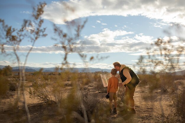 Full shot kid and father in desert