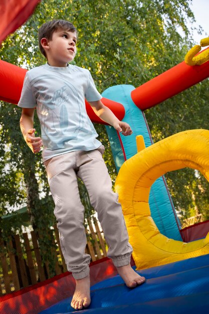 Foto gratuita bambino a tutto campo che si diverte nella casa di rimbalzo