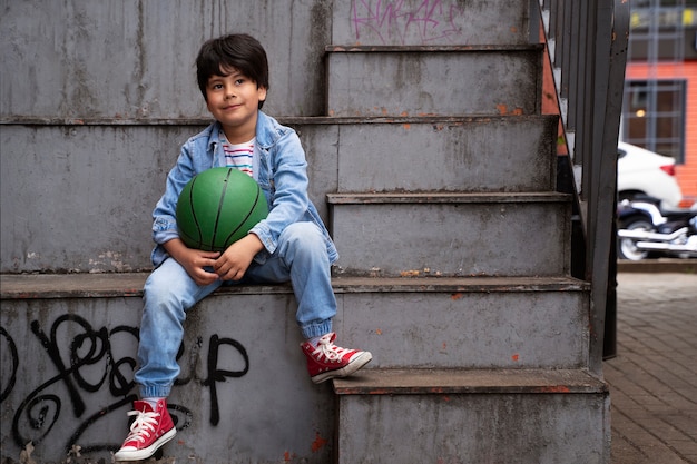 Full shot kid holding ball