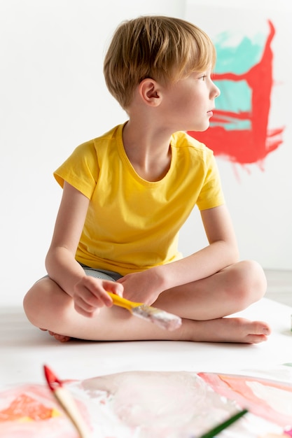 Full shot kid holding brush