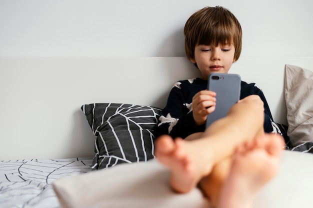 Foto gratuita telefono pieno della holding del bambino del colpo