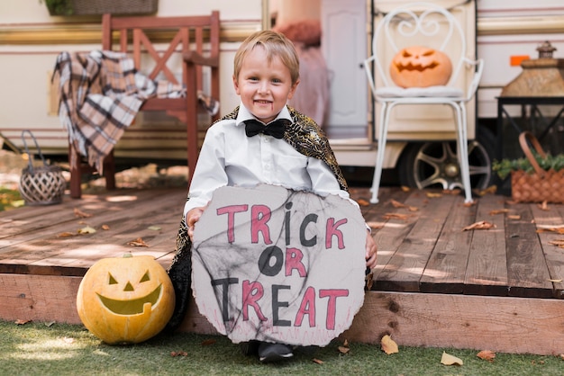 Foto gratuita full shot kid holding dolcetto o scherzetto segno