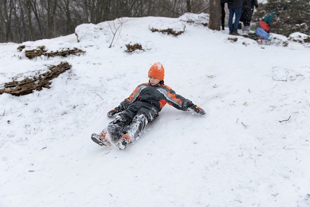 Бесплатное фото Полный снимок ребенка, лежащего в снегу