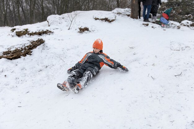 Полный снимок ребенка, лежащего в снегу