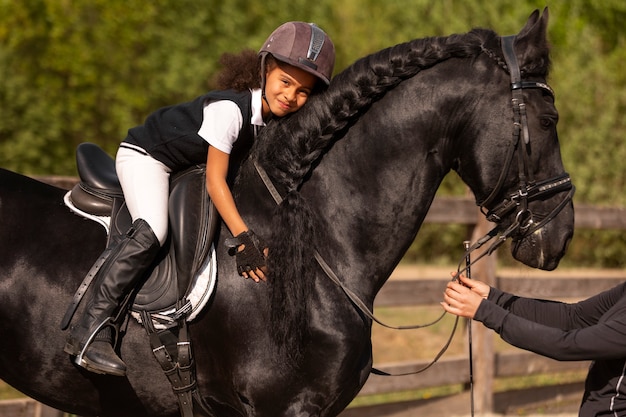 Foto gratuita ragazzo a tutto campo che impara a cavalcare