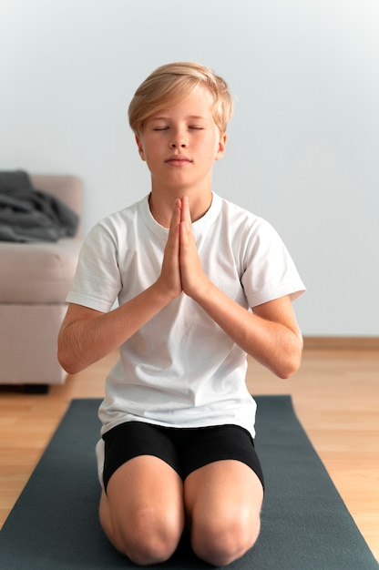 Free photo full shot kid meditating