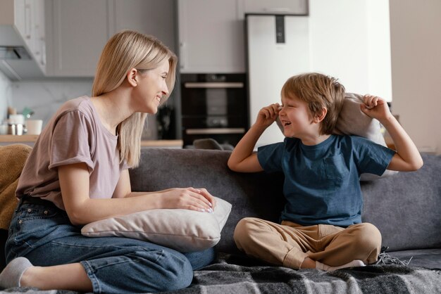 Full shot kid and mother on couch