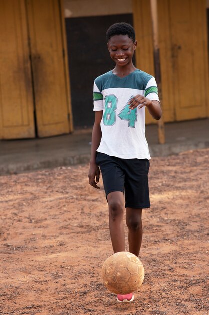 Free photo full shot kid playing with ball outside