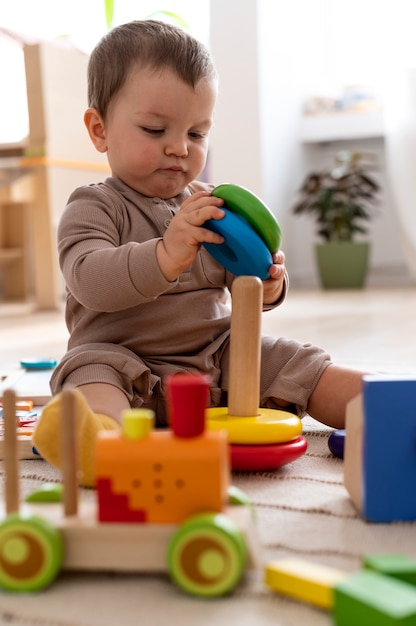 Полный снимок ребенка, играющего с красочными игрушками