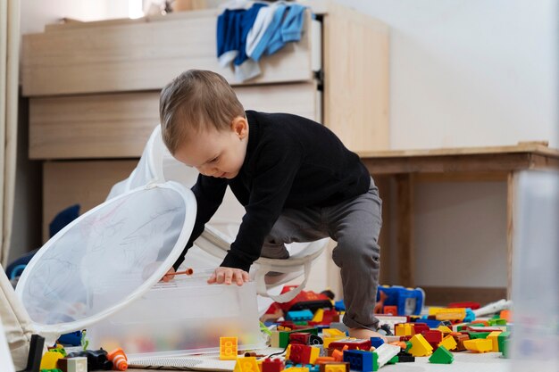 Full shot kid playing with container