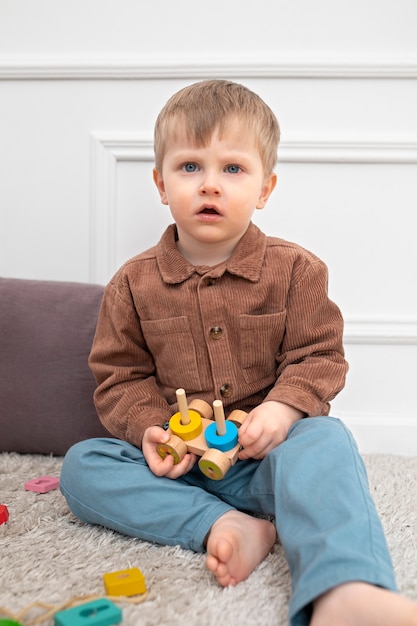 Полный снимок ребенка, играющего с развивающей игрушкой