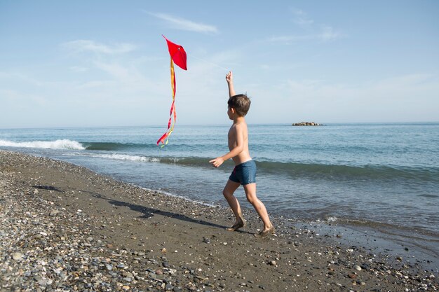 Full shot kid playing with kite