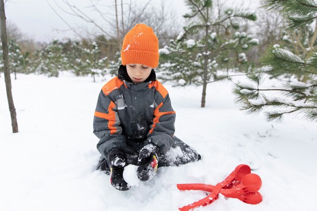 Полный снимок ребенка, играющего со снегом