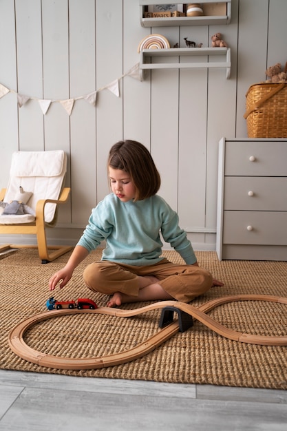 Полный снимок ребенка, играющего с поездом