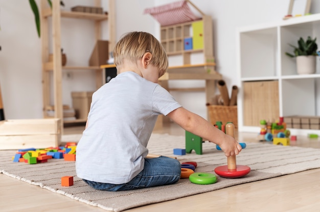 木のおもちゃで遊ぶフルショットの子供