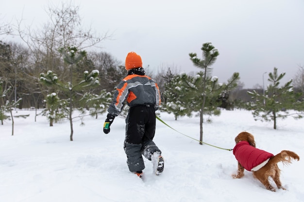 犬と一緒に走っているフルショットの子供